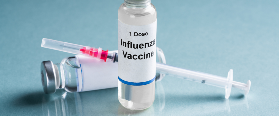 Vial of influenza vaccine with syringe representing flu vaccination services